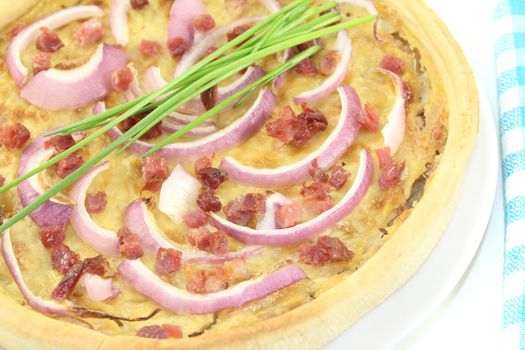 fresh Onion tart with leeks and bacon on a light background
