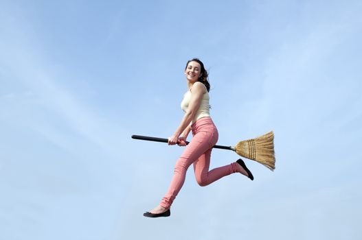 happy young woman flying with a broom