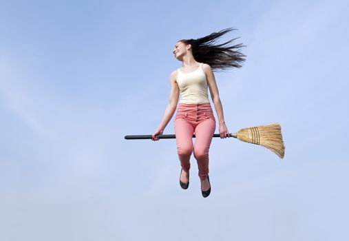  happy young woman flying with a broom