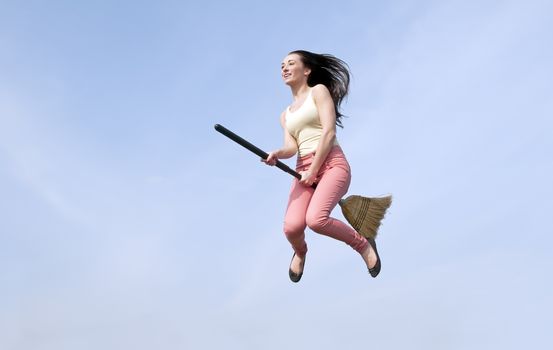 happy young woman flying with a broom