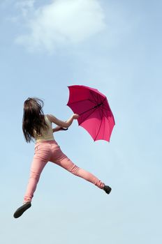 young woman jumping with red umbrella, rear view