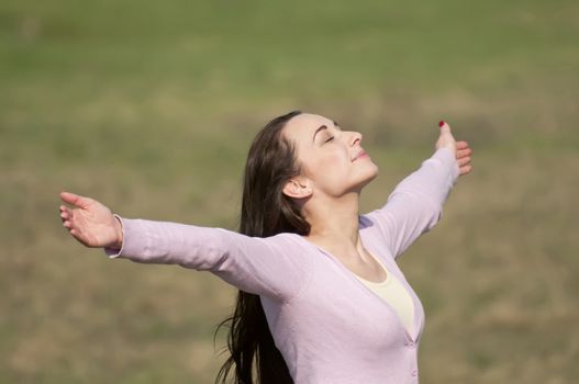 young woman feeling free with arms wide open