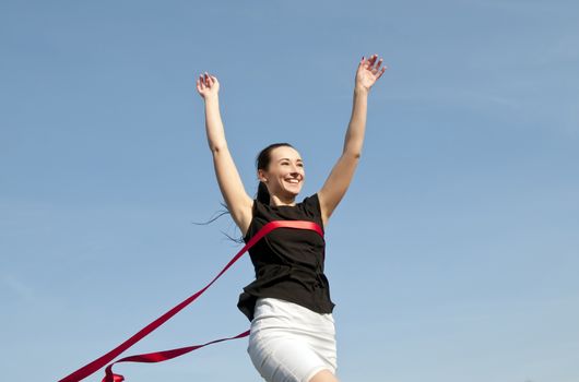 woman in skirt crossing finishing line