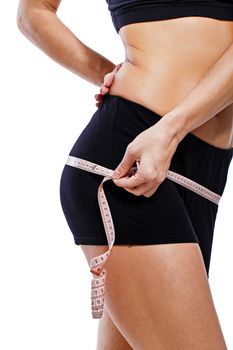 Girl measuring hip circumference after a grueling workout, isolated on white background