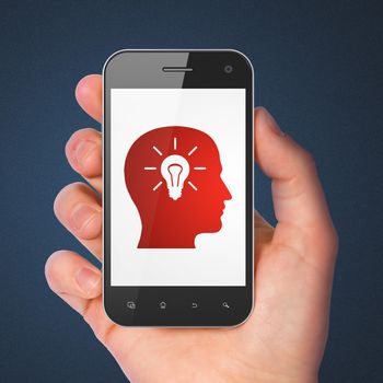 Education concept: hand holding smartphone with Head With Light Bulb on display. Generic mobile smart phone in hand on Dark Blue background.