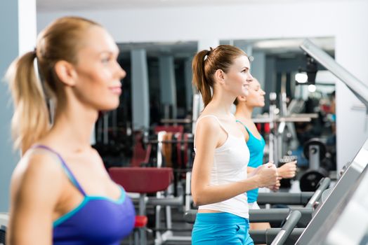 women running on a treadmill in a fitness club, sport in the fitness club