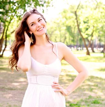 Portrait of an attractive woman in the park, her hair and smiling