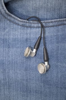 Music earphone in a denim jeans pocket