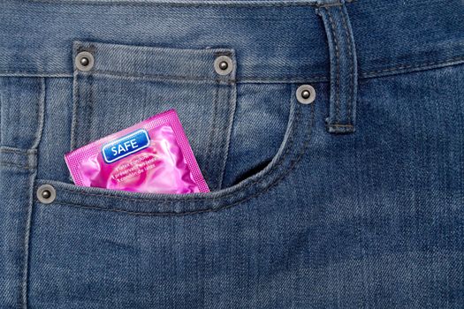 Pink wrapped condom on a demin jean pocket