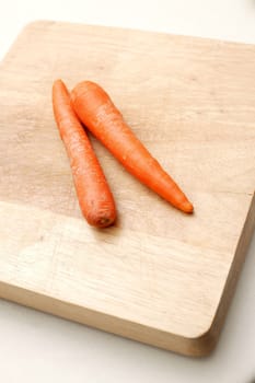 Carrots isolated on a wooden chopping board