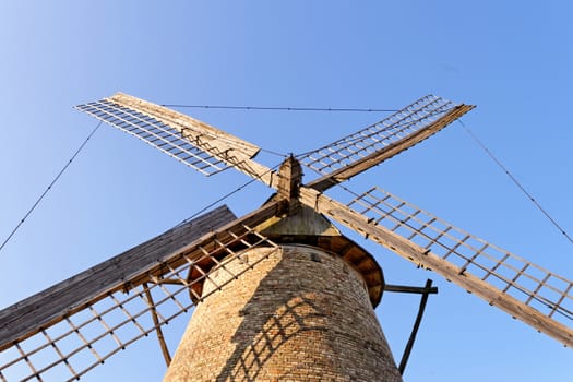 Old wooden windmill against the blue sky