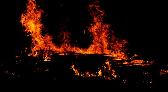 red flames of huge bonfire or campfire as black backgorund