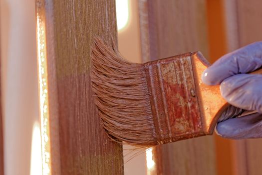 planks fence dyeing with brown paint and brush