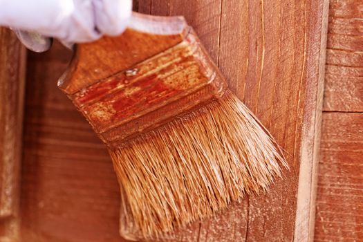 planks fence dyeing with brown paint and brush