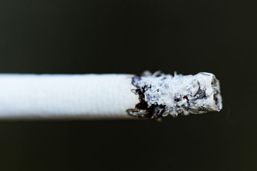 Smoking a cigarette against a dark background