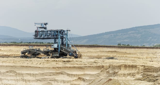 Coal mining in an open pit with huge industrial machine