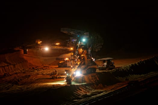 Coal mining in an open pit with huge industrial machine at night shoot