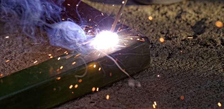 Iron welding with bright light and smoke at manufacturing