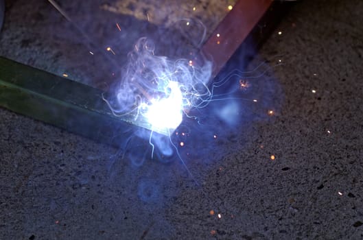 Iron welding with bright light and smoke at manufacturing