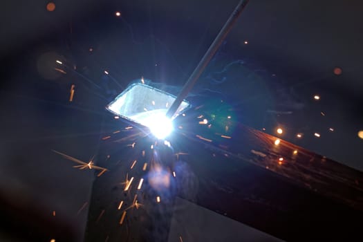 Iron welding with bright light and smoke at manufacturing