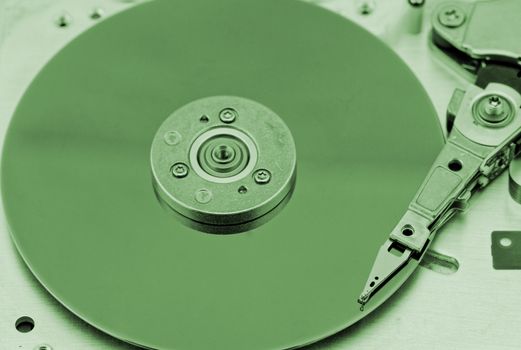 Open computer hard drive on white background with green (HDD, Winchester)