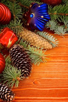 Arrangement of Christmas Decoration with Spruce Branch, Red Bauble, Red Gift Box, Shape Star and Fir Cones closeup on Wooden background