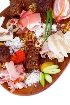 Arrangement of Various Smoked, Boiled and Uncooked Ham with Mustard, Salt, Brown Bread and Spices closeup on Wooden Plate