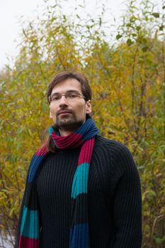 man with glasses on a background of autumn forest