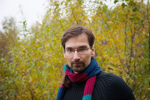 man with glasses on a background of autumn forest