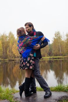 Beautiful loving couple dancing at a lake in autumn