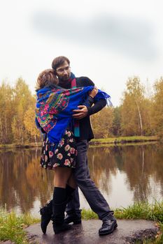 Beautiful loving couple dancing at a lake in autumn