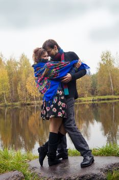 Beautiful loving couple dancing at a lake in autumn