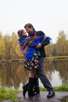 Beautiful loving couple dancing at a lake in autumn