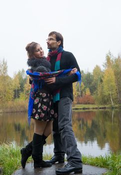 Beautiful loving couple dancing at a lake in autumn