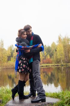 Beautiful loving couple dancing at a lake in autumn