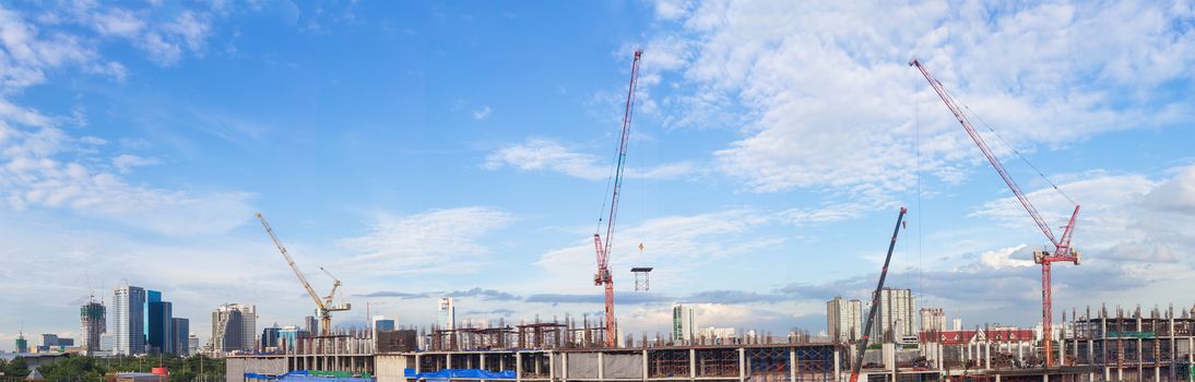 Construction site with crane worker and building as panorama