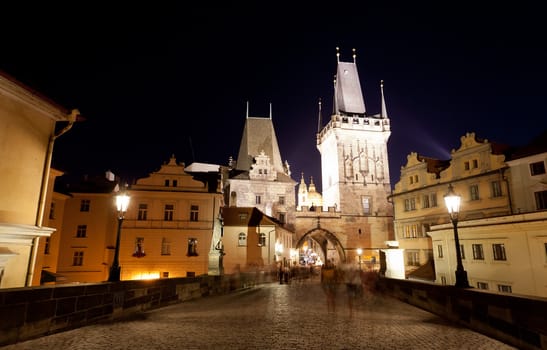 Tourists near Charles bridge in Prague at night.
