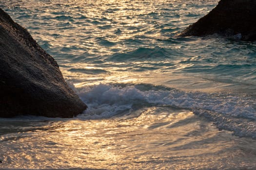 Big stones on an ocean coast against a sunset in tropics, Thailand