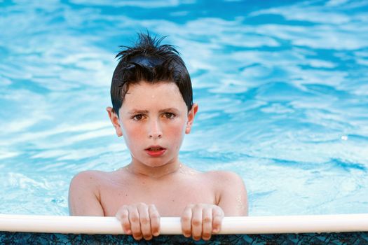 Boy in the swimming pool with clear water