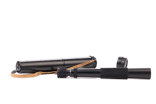 Black cover and spyglass lying on a white background