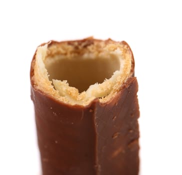 Bitten waffle rolls coated chocolate. Close up. White background.