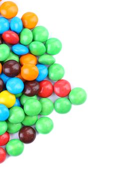 Small versicolor chocolate drops on a white background