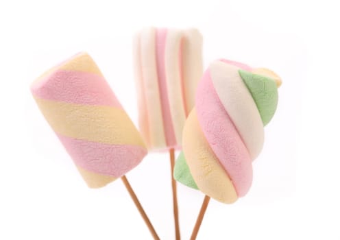 Three different colorful marshmallow on sticks. White background.