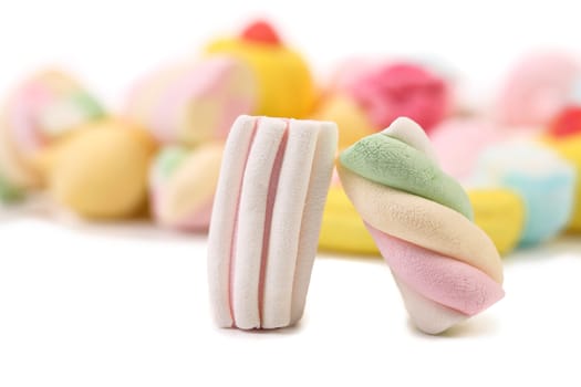 Two colourful marshmallow on background of other. Close up. White background.