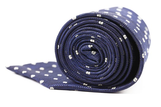 Folded blue tie with white speck. White background.