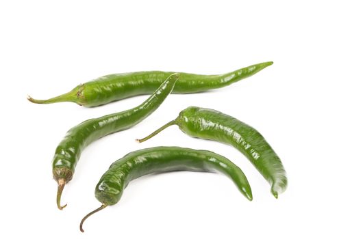 Four green peppers isolated on a white background