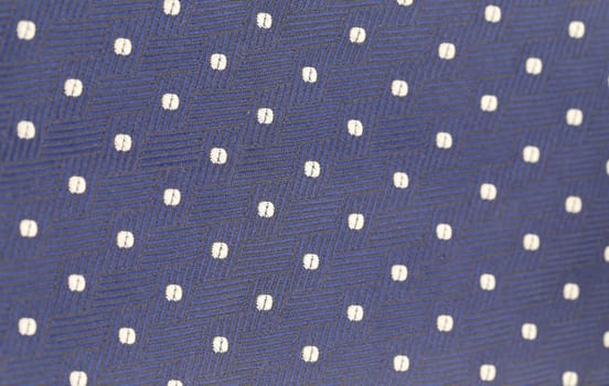 Background of blue tie with white speck. Texture.
