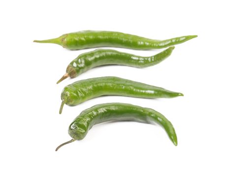 Four green peppers isolated on a white background