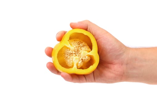 Hand holds half of yellow pepper. White background.