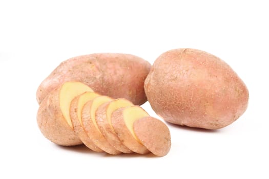 Ripe red potatoes and slices on a white background